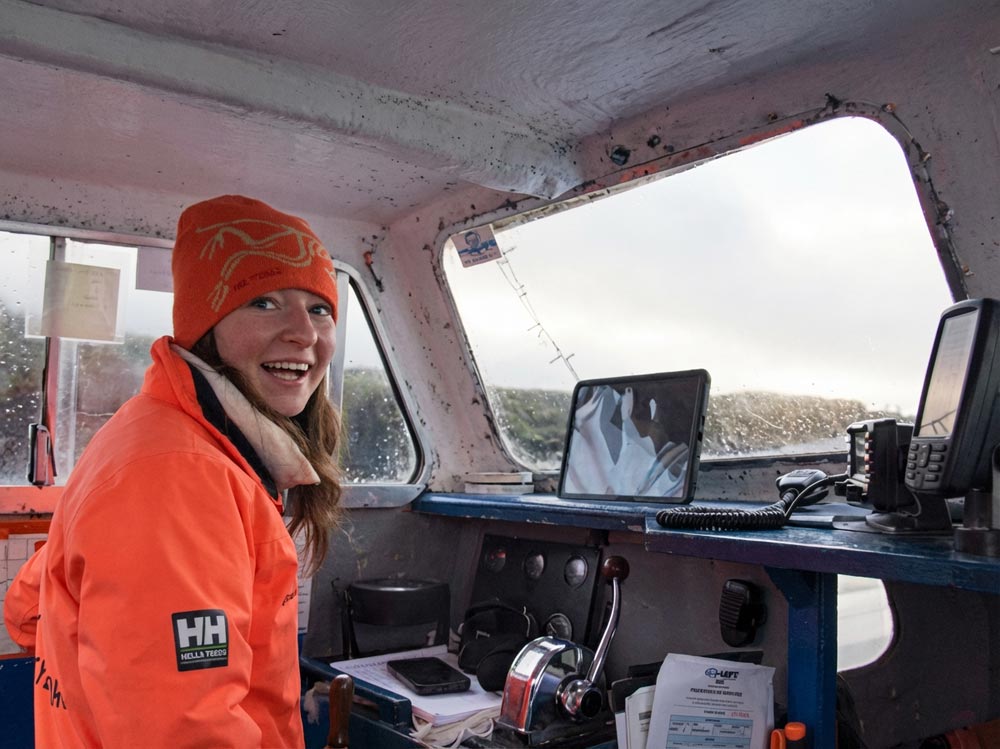 Smiling young woman at the skipper's wheel of Ireland's Eye Ferry
