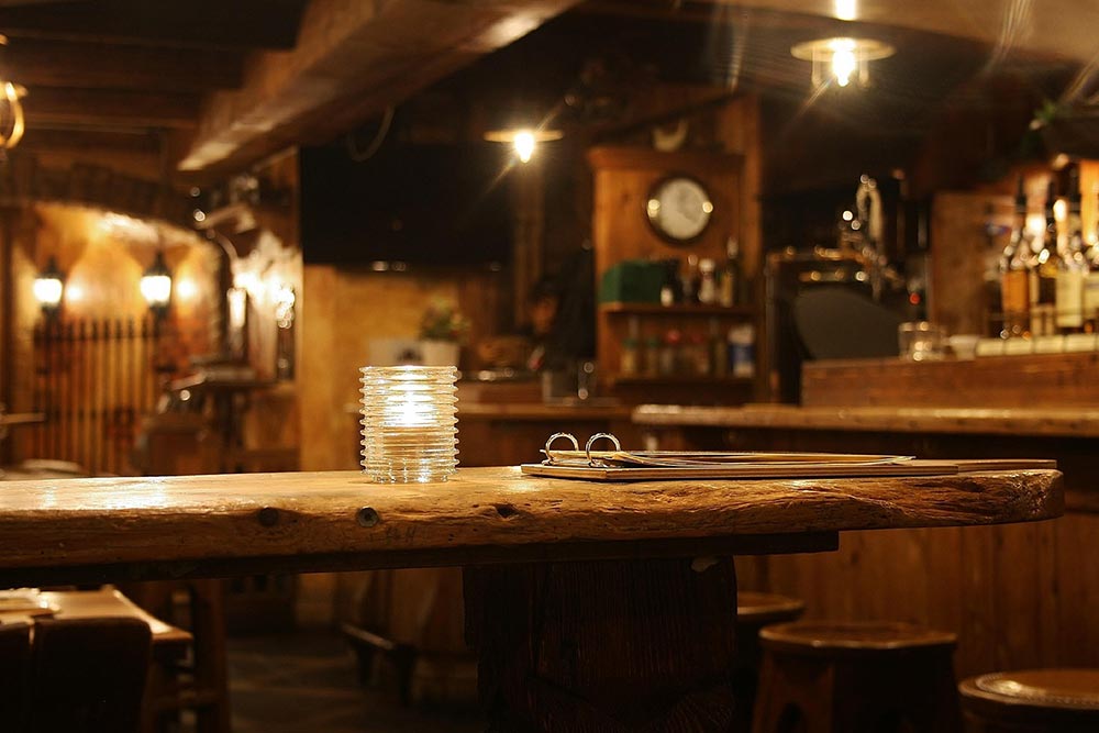 Close-up of candle and clipboard on the counter in a dimly lit bar Interior.