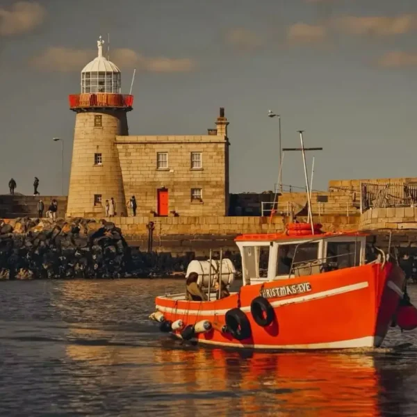 Ireland's Eye Ferry entering Howth Harbour at sunset.