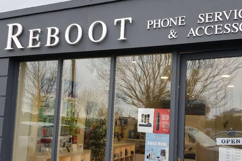Gray shopfront of Reboot Tech Support shop in Howth, with white lettering.