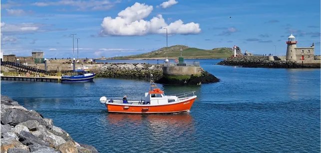 Orange Ireland's Eye Ferry crosses Howth Harbour.